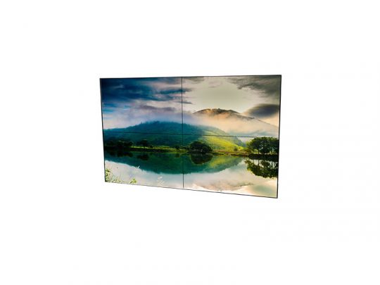 Steglose Videowand 2x2 aus vier 55-Zoll-Displays zeigt ein brillantes Landschaftsmotiv mit Bergen, grüner Natur und See unter wolkigem Himmel. Die nahtlose Videowand ist ideal für professionelle Präsentationen und kann gemietet oder gekauft werden.
