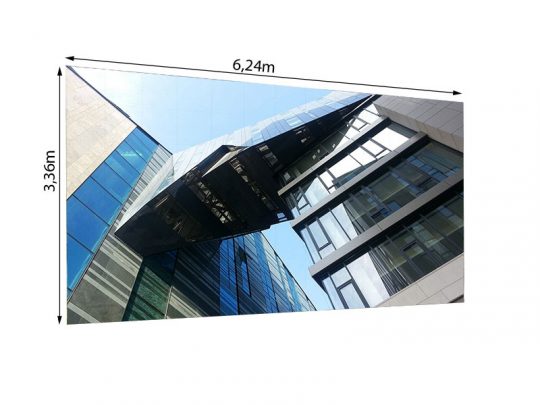 Moderne LED Wand 6.24m x 3.36m mit 3,75mm Pixelpitch vom Typ LEDCON SL-3.75SI vor einem gläsernen Stahlgebäude, aufgenommen aus der Froschperspektive mit klarem blauen Himmel - perfekt zum Mieten für Events, Messen oder Werbung.
