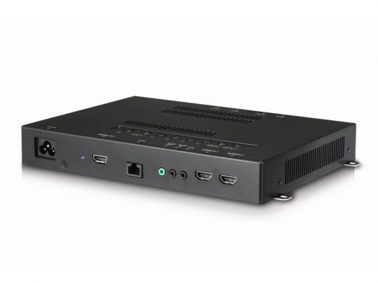 Schwarzes Elektronikgerät, rechteckig mit Lüftungsschlitzen, auf weißer Oberfläche; zeigt verschiedene Anschlüsse wie HDMI, Audio-Buchsen, Ethernet, USB und Netzteil-Eingang - ideal als Media Player oder Mini-PC zum Mieten oder Kaufen.
