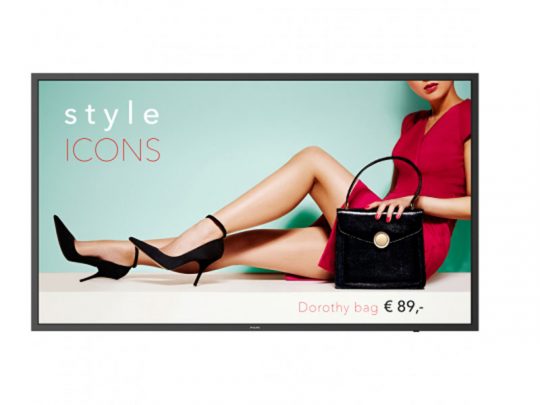 Eine Frau in einem roten Kleid sitzt mit überkreuzten Beinen, trägt schwarze High Heels und hält die schwarze Dorothy Handtasche. Im Hintergrund steht "style ICONS". Die Anzeige bewirbt die Dorothy Bag für 89 € mit der Möglichkeit, sie zu kaufen oder zu mieten.