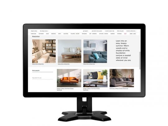 Computerbildschirm zeigt die moderne Möbelplattform "xyz" mit verschiedenen Sofas und Wohnzimmer-Einrichtungen, die zum Kaufen oder Mieten angeboten werden. Auf der klar strukturierten Website sind Produktbilder und Beschreibungen in einem minimalistischen Design dargestellt.