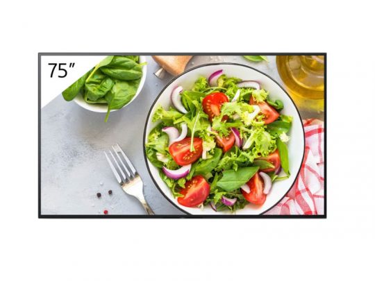 Großer 75-Zoll-Bildschirm zeigt ein Bild von frischem Salat mit Tomaten, Kopfsalat, Spinat und roten Zwiebeln; daneben liegen eine Gabel, frische Spinatblätter, eine Ölflasche und eine rot-karierte Serviette. Perfekt zum Mieten oder Kaufen für Food-Events oder Präsentationen.